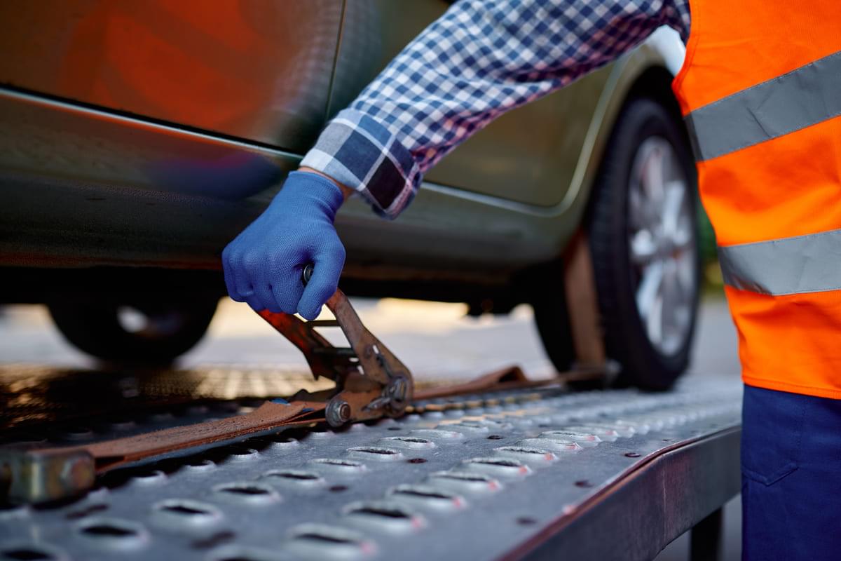 Tow truck driver fixing car